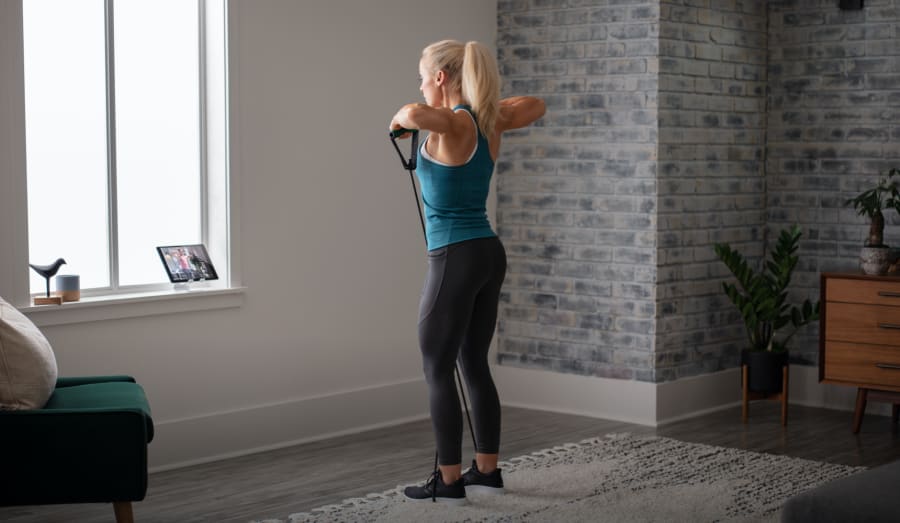 Woman working out using the Medium Resistance Tube.