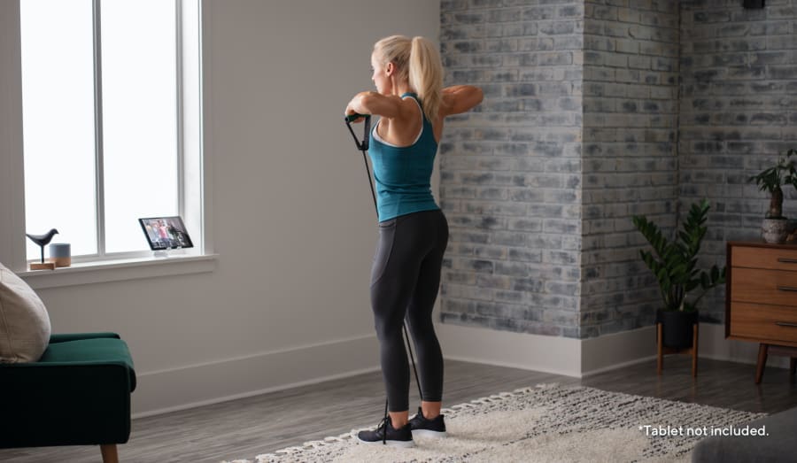 Woman working out using the Medium Resistance Tube.