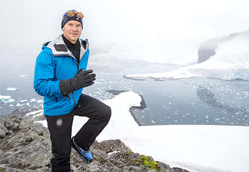 man running along side a glacier