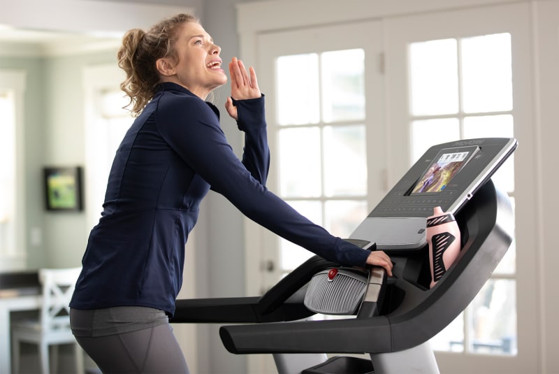 Woman walking on a treadmill and shouting in the air.