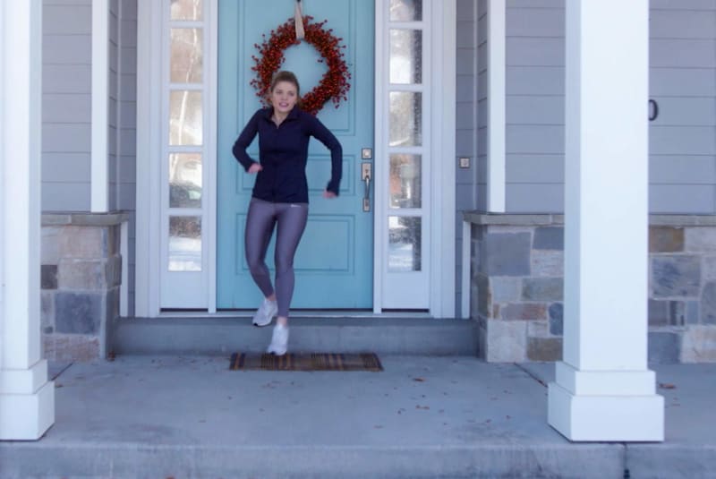 Woman getting ready for a jog outside of her home.