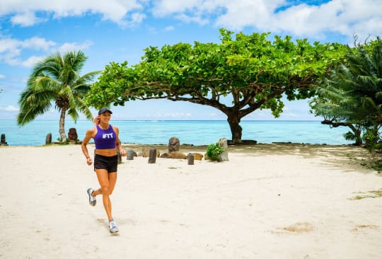Trainer jogging on the beach