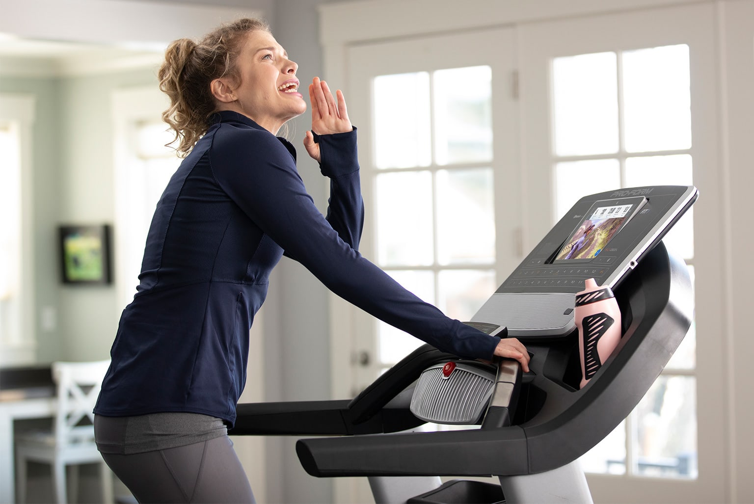 Woman walking on a treadmill and shouting in the air.
