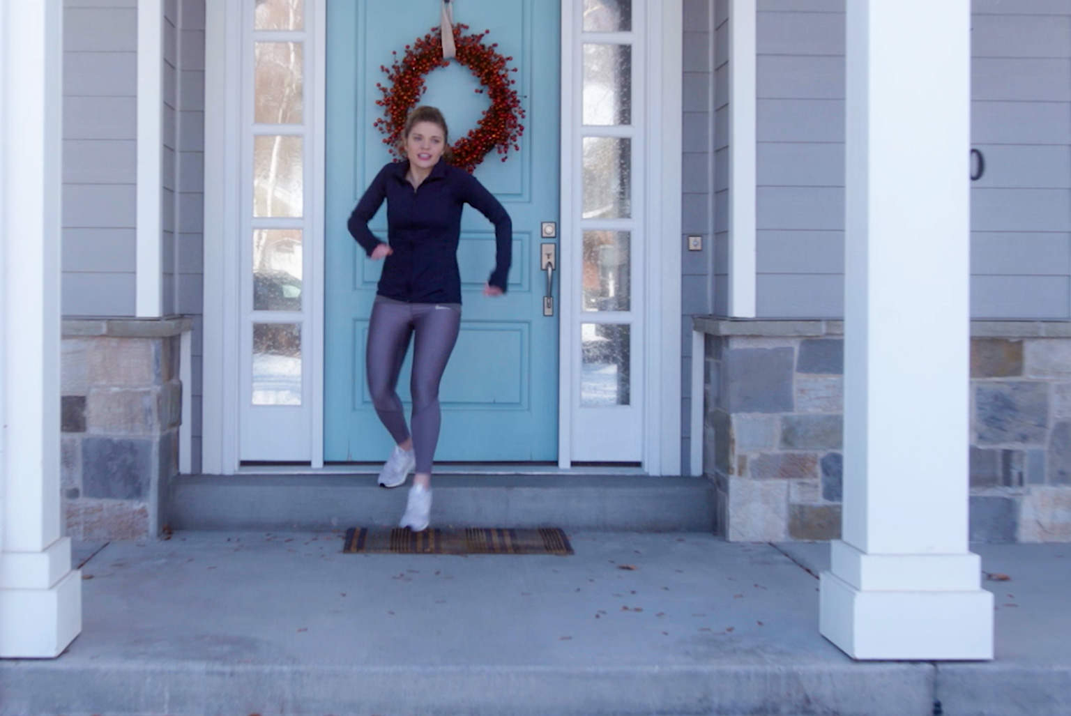 Woman getting ready for a jog outside of her home.